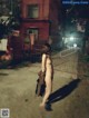 A naked woman walking down a street at night.