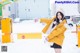 A woman in a yellow jacket is standing in the snow.