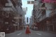 A woman in a red dress walking down a street.