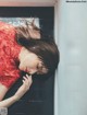 A woman in a red dress laying on a window sill.