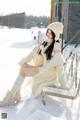 A woman sitting on a bench in the snow.