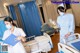 A nurse in a hospital room with a patient in a bed.