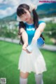 A woman in a blue shirt and white skirt holding a can of milk.