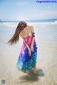 A woman in a colorful dress standing in the water.