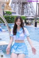 A woman in a blue and white outfit standing in a pool.