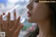 A woman drinking water from a glass. 