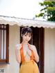 A woman in an orange dress posing for the camera.