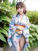 A woman in a blue and white kimono posing for the camera.