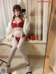 a woman in a red bra top and white stockings taking a selfie