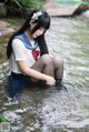 A woman in a sailor outfit is sitting in the water.