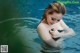 A woman in a black bathing suit in a pool.