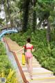 A woman in a red and white polka dot bathing suit walking up some stairs.