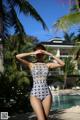 A woman in a bathing suit standing next to a pool.