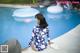 A woman sitting on the edge of a swimming pool.