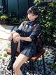 A woman sitting on a chair in a school uniform.