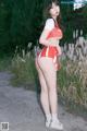 A woman in a red and white cheerleading uniform posing for a picture.