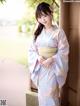 A woman in a blue and pink kimono posing for a picture.