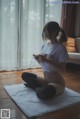 A woman sitting on the floor playing a video game.