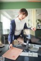 A woman sitting at a desk in front of a computer.