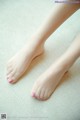 A close up of a woman's bare feet with pink nail polish.