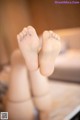 A close up of a person's bare feet on a bed.