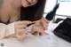 A woman sitting at a table with a pen in her hand.