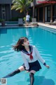 A woman in a sailor outfit is standing in a pool.